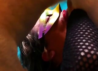 فتاة مقنعة في زي فاسق تمارس الجنس الفموي مع قضيب كلب أبيض