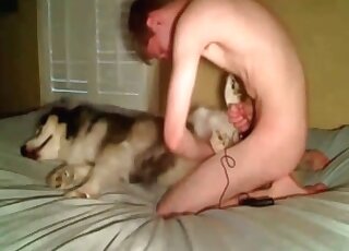 رجل نحيف يمارس الجنس مع كلبه على السرير ويستمتع به